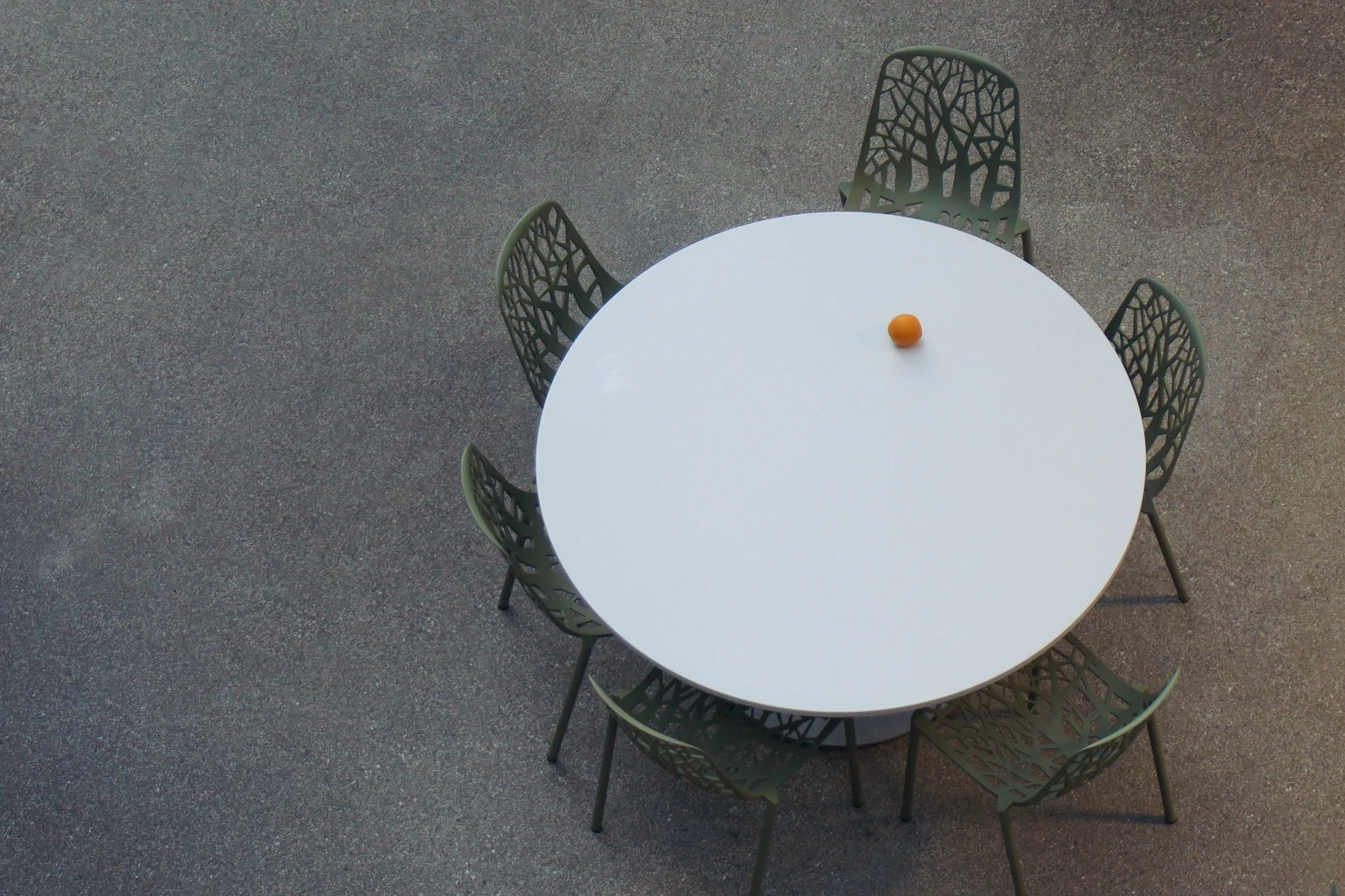 mesa redonda con sillas alrededor y una naranja